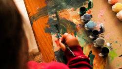 Mano de niño pintando con témperas