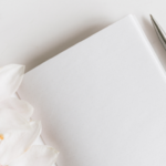 Cuaderno, lapicera y flores