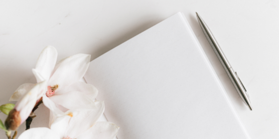Cuaderno, lapicera y flores